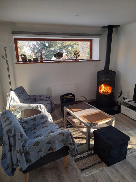 Poêle à bois allumé et fauteuils cosy pour les soirées d'hiver